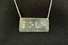 Load image into Gallery viewer, A functional, tactile braille necklace that reads "love" in grade 2 braille. The piece is bright, polished silver with gold dots.