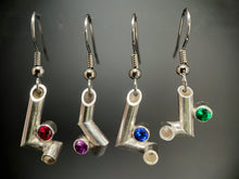 Load image into Gallery viewer, Four earrings hanging side by side. Each is made of sterling silver tubing with sharp bends making it twist and turn in three dimensions. Each has a different gemstone sitting in one of the bends - ruby, purple sapphire, sapphire, and emerald.