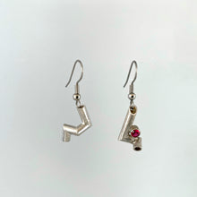 Load image into Gallery viewer, A pair of earrings. Each is made of sterling silver tubing with sharp bends in it, each earring in a different pattern. The earring on the right also has a tube-set ruby.