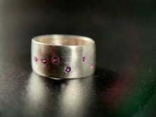 Load image into Gallery viewer, A thick, sterling silver ring with a random scattering of flush-set purple sapphires.