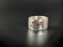 Load image into Gallery viewer, A thick, sterling silver ring with a random scattering of flush-set rubies.