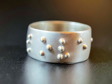 Load image into Gallery viewer, A sterling silver ring, with the word "love" visible in accurate, functional, grade 2 braille.