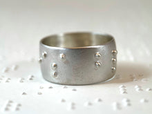 Load image into Gallery viewer, A sterling silver ring with the words "is blind" in accurate, functional, grade 2 braille.