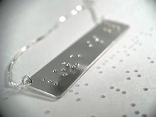 Load image into Gallery viewer, A sterling silver necklace that reads "love is blind" in contracted, grade 2 braille. The dots for the word "blind" are done in gold.
