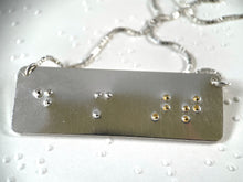 Load image into Gallery viewer, A functional, tactile braille necklace that reads "do more art" in grade 2 braille. The word 'art' is done in gold.