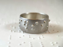 Load image into Gallery viewer, A sterling silver ring reading "persist" in accurate, functional, grade 2 braille.