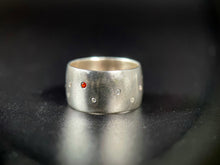 Load image into Gallery viewer, A sterling silver ring with a random scattering of flush set white moissanite stones and a single flush-set orange sapphire..