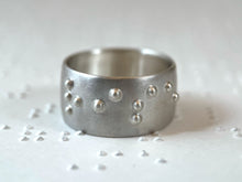 Load image into Gallery viewer, A sterling silver ring reading "rise" in accurate, functional, grade 2 braille.