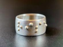 Load image into Gallery viewer, A sterling silver ring reading "rise" in accurate, functional, grade 2 braille.