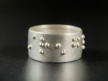 Load image into Gallery viewer, A sterling silver ring that reads "strength" in functional, contracted, grade 2 braille.