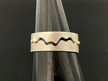 Load image into Gallery viewer, A sterling silver ring with a winding gap running down the middle of the band. Small dots of 18k yellow gold sit in the middle of the gap as spacers.

