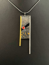 Load image into Gallery viewer, A rectangular pendant, framed on three sides with wire. The wire on the left is gold, with the top and right sides being silver. The frames hang down past the body of the pendant on the bottom. The main pendant is reticulated silver, with a rough organic texture and flecks of gold in the crevices. It is split diagonally through the middle, with a lab grown orange sapphire set in the gap.

