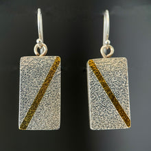 Load image into Gallery viewer, Rectangular earrings in textured silver. Each has a diagonal line of 24k gold running in opposite directions on it.
