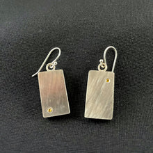Load image into Gallery viewer, Rectangular sterling silver earrings with a diagonal lined texture. Each earring has a single yellow sapphire, one in the lower left corner and the other in the upper right corner.
