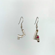 Load image into Gallery viewer, A pair of earrings. Each is made of sterling silver tubing with sharp bends in it, each earring in a different pattern. The earring on the right also has a tube-set ruby.
