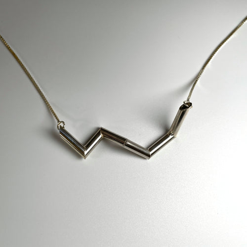 A necklace of sterling silver tubing, in a zigzag shape.