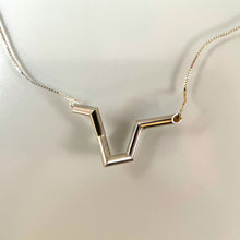 Load image into Gallery viewer, A necklace made of silver tubing, with sharp turns and twists. The overall shape is vaguely like the top of a heart.
