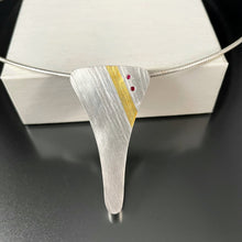 Load image into Gallery viewer, A Y shaped pendant in textured sterling silver. The texture is an organic looking lined texture, going from upper left to lower right. In the upper right corner is a stripe of gold, and further towards the corner are two small rubies in a parallel line.
