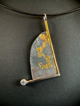 Load image into Gallery viewer, A triangular necklace, hanging at an angle. The silver has a terrain-like pattern, and is bordered on the right and bottom with wire - gold on the right, silver on the bottom. The silver wire terminates in a lab-grown moissanite gem. The third side is a raw, curving edge. There is a branching gold pattern winding its way down the necklace.

