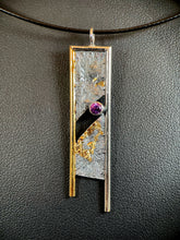 Load image into Gallery viewer, A rectangular necklace, hanging vertically. The top and sides are bordered in wire - gold on the left, with the rest silver. The sides hang below the edge of the main piece, with the silver side hanging lower than the gold. There is a diagonal gap in the main body running through the middle from upper right to lower left. In the upper right of that gap is a lab-grown purple sapphire. There are bits of gold in the recessed portions of the reticulated, terrain-like texture of the silver of the main body.
