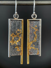 Load image into Gallery viewer, A rectangular pair of earrings, hanging vertically. The top and both sides are framed in wire - silver on the top and outside edge, gold on the inside. The gold border on each earring hangs lower, with the silver dropping just below the edge of the rectangle. The center of the earring is reticulated silver, in a terrain-like pattern. Both earrings have a winding, branching pattern of gold in their recessed portions.
