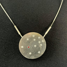 Load image into Gallery viewer, A round silver pendant with a scattering of small round white moissanite stones. In the lower left is a single lab-grown ruby.
