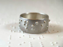 Load image into Gallery viewer, A sterling silver ring reading &quot;persist&quot; in accurate, functional, grade 2 braille.
