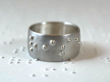 Load image into Gallery viewer, A sterling silver ring reading &quot;rise&quot; in accurate, functional, grade 2 braille.
