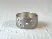 Load image into Gallery viewer, A sterling silver ring reading &quot;shine&quot; in accurate, functional, grade 2 braille.
