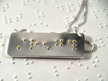 Load image into Gallery viewer, A sterling silver necklace with the word &quot;strength&quot; written in contracted, grade 2 braille. The dots are done in gold.

