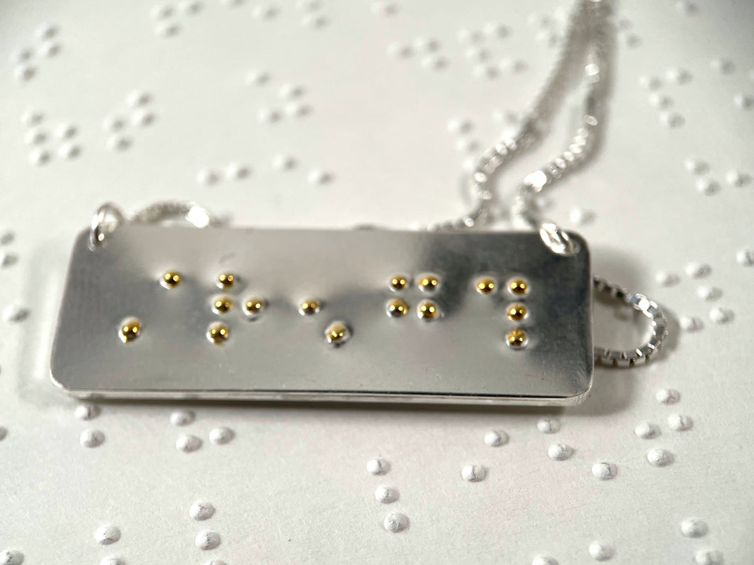 A sterling silver necklace with the word 